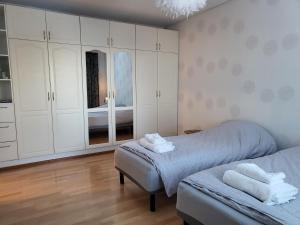 a bedroom with two beds and white cabinets at Home Apartment Haukipudas in Oulu