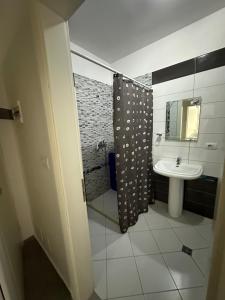 a bathroom with a shower curtain and a sink at Summer Holiday in Shëngjin