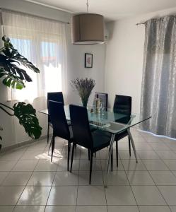 a dining room with a glass table and chairs at Apartman Jadro in Solin