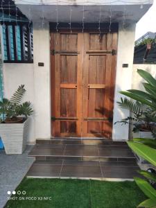a large wooden door on a house with some plants at De sepakat cottage private pool in Kuantan +24 photos