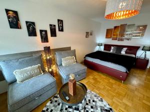 a bedroom with a bed and a couch and a table at Sunset View Apartment with Logia in Ettlingen