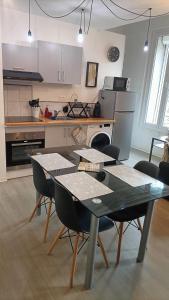 a kitchen with a table and chairs in a room at F1 en duplex coquelicot in Lamalou-les-Bains
