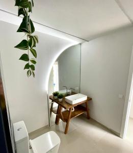 a bathroom with a toilet and a table with a plant at Casa Del Mar in Costa de Antigua