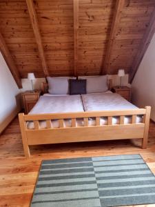 a bed in a room with a wooden ceiling at Ferienwohnung Metzner Harnsbach in Burgebrach