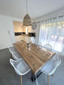 - une table et des chaises en bois dans la cuisine dans l'établissement Villa Victoria : Clim - Garage / 8 pers au Calme, à Roquebrune-Cap-Martin
