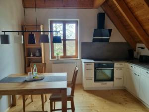 a kitchen with a wooden table and a dining room at Ferienwohnung Metzner Harnsbach in Burgebrach