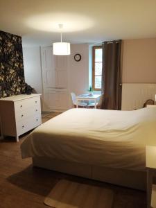 a bedroom with a white bed and a table at A La Halte Des Gorges in Nevy-sur-Seille