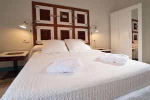 a bedroom with a white bed with towels on it at Hotel Hostal Chic in Sant Feliu de Guixols