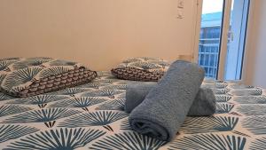 a bed with pillows and towels on top of it at Studio Cosy avec balcon et garage privé in Le Mans