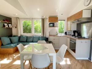 eine Küche und ein Wohnzimmer mit einem Tisch und einem Sofa in der Unterkunft Ocean Garden Chalet Renesse in Renesse