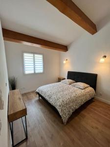 a bedroom with a bed and a table and a window at Villa Victoria : Clim - Garage / 8 pers au Calme in Roquebrune-Cap-Martin