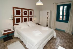 a bedroom with a large bed with white sheets at Hotel Hostal Chic in Sant Feliu de Guixols