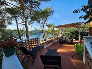 a deck with chairs and tables and a view of the water at Studio Dubravka in Mali Lošinj