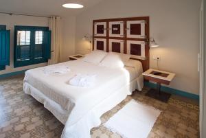 桑特费柳德吉克索尔斯Hotel Hostal Chic的卧室里有一张白色的大床，床上放着毛巾