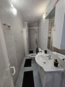 biała łazienka z umywalką i toaletą w obiekcie Studio Dubravka w miejscowości Mali Lošinj
