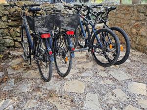 two bikes are parked next to a stone wall at Studio Dubravka in Mali Lošinj
