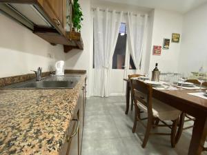 uma cozinha com um lavatório e uma mesa com cadeiras em (The Milan Life) Niguarda / Bicocca em Milão