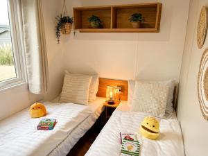 two twin beds in a small room with a window at Ocean Garden Chalet Renesse in Renesse