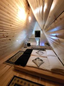 バリウグにあるCabana Vânătorilor A Frame Greenの木製の壁に大きなベッドが備わるベッドルーム1室