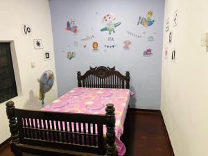 een kinderkamer met een wieg en een muur met disney stickers bij AUD Home Stay 