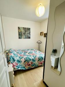 una camera da letto con un letto con copriletto floreale di Joli appartement avec parking a Montbéliard