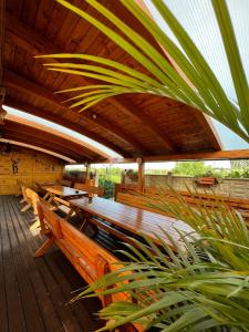terraza de madera con bancos y techo de madera en Vila Carlos, en Băile Felix