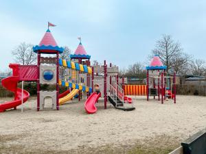 a playground with a slide in the sand at Ocean Garden Chalet Renesse in Renesse