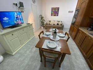 uma sala de estar com uma mesa e uma televisão em (The Milan Life) Niguarda / Bicocca em Milão
