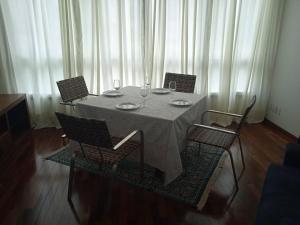 uma mesa com quatro cadeiras e copos de vinho em Ap loft Belvedere fronte shopping BH em Belo Horizonte