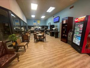 un restaurante con mesas y sillas y una máquina de bebidas en Days Inn by Wyndham Lake Park/Valdosta, en Lake Park