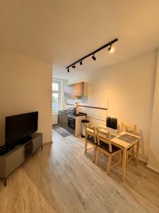 a living room with a table and a kitchen at A&V Apartments Arena Nähe in Gelsenkirchen