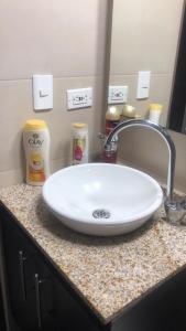 a bathroom counter with a white sink and a mirror at apartamento privado in Bogotá