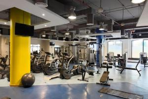 a gym with several treadmills and machines in it at Urban Heaven, Premium Hostel - JBR - Walk To Beach, Metro Station in Dubai