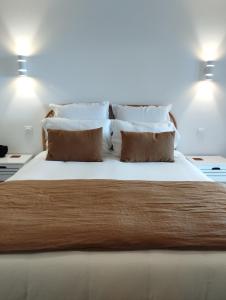 1 dormitorio con 1 cama grande con sábanas y almohadas blancas en Au coucher du lac, en Publier