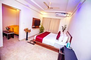pokój hotelowy z łóżkiem i telewizorem w obiekcie ZIONS AIRPORT HOTEL w mieście Bengaluru