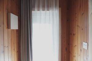 a window with a curtain in a room at At corner resort & garden in Jeju