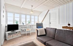 een woonkamer met een bank en een tv bij Nice Home In Hjrring With Sauna in Hjørring