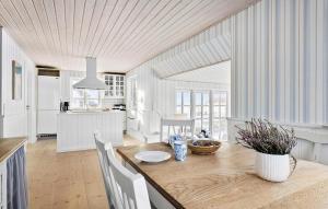 een keuken en eetkamer met een houten tafel en stoelen bij Nice Home In Hjrring With Sauna in Hjørring
