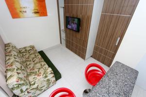Habitación con 1 cama y 2 sillas rojas en L'acqua Diroma - Suítes confortáveis - Diversão garantida, en Caldas Novas