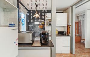 a kitchen with white cabinets and a blender on a counter at Lovely Home In Weitendorf With Kitchenette in Weitendorf