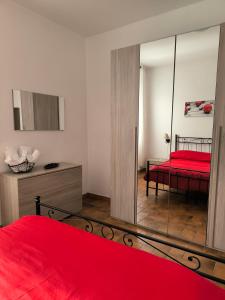 una camera da letto con un letto rosso e uno specchio di La Corte a Morlupo Altre 6 foto