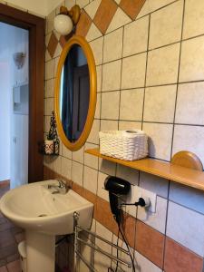 bagno con lavandino e specchio a parete di La Corte a Morlupo