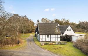 a white and black house on a dirt road at Beautiful Home In Aakirkeby With Wifi in Åkirkeby
