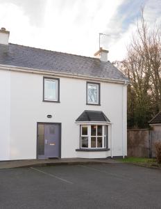 uma casa branca com uma porta azul em 5 Bruach na hAbhann em Clonakilty