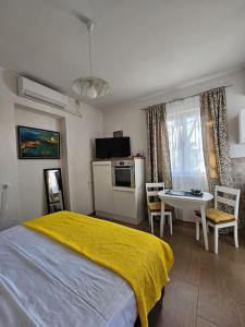 a bedroom with a bed and a table with chairs at Studio Dubravka in Mali Lošinj