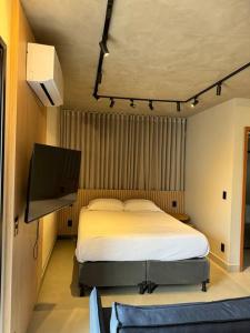 a bedroom with a bed and a flat screen tv at Apto Novo próx Center Shopping in Uberlândia