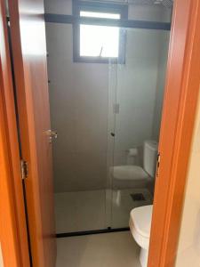 a bathroom with a toilet and a glass shower at Apto Novo próx Center Shopping in Uberlândia