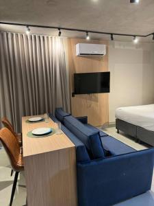 a room with a couch and a table and a bed at Apto Novo próx Center Shopping in Uberlândia