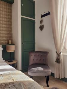 a bedroom with a green door and a chair next to a bed at La maison de Mona in Carcassonne +22 photos