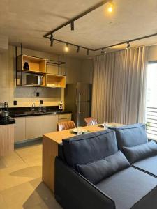 a living room with a couch and a table and a kitchen at Apto Novo próx Center Shopping in Uberlândia